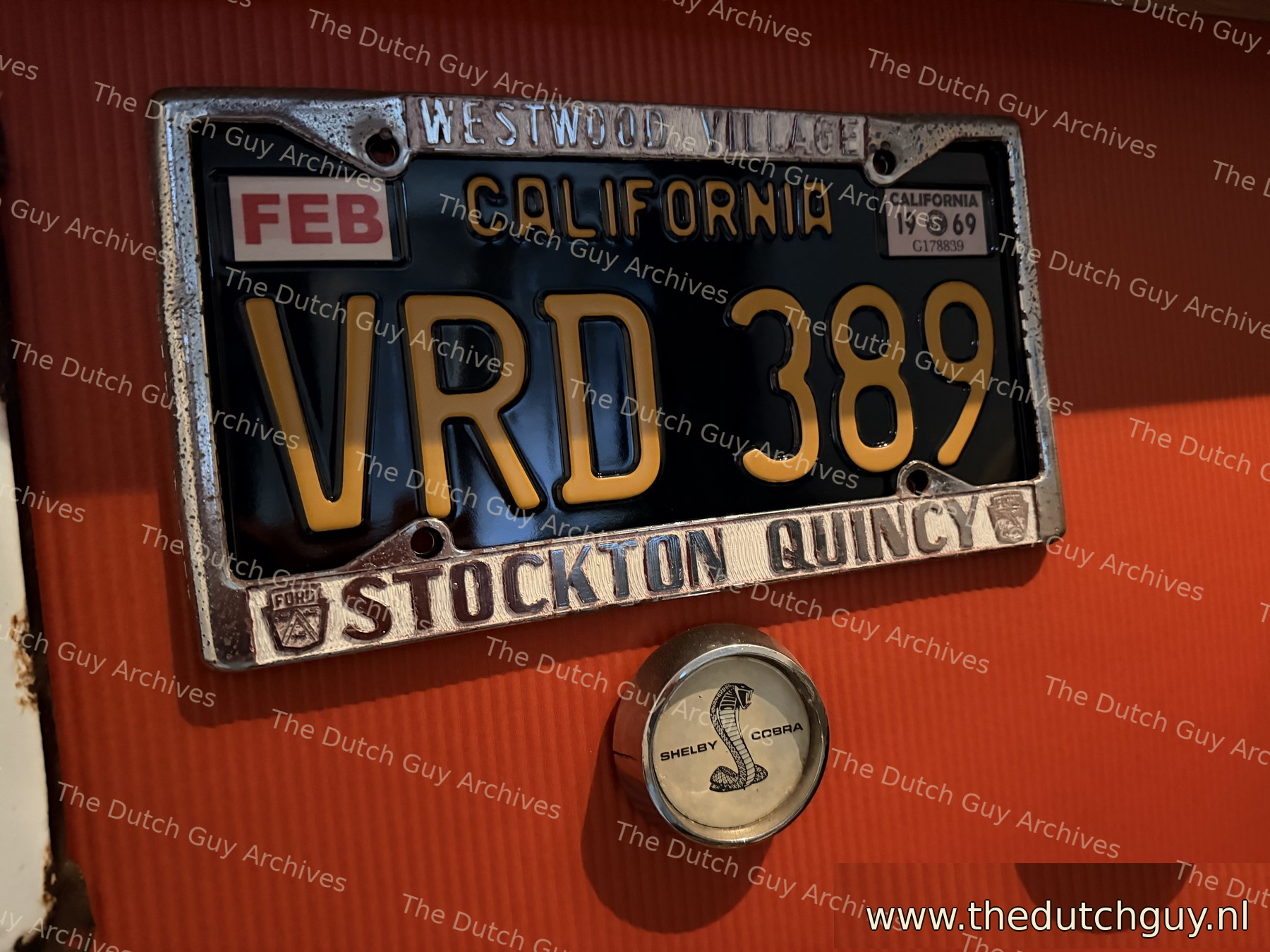 California 1969 license plate VRD 389 in a Westwood Village Stockton Quincy dealer frame, with a GT500 wheel cap below